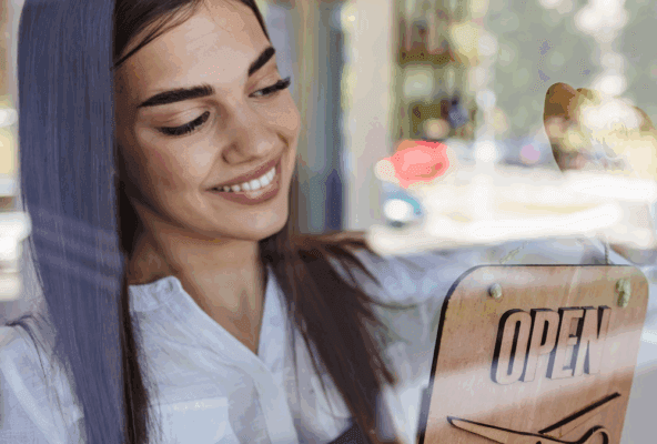 Salon and spa owner with an open sign, representing the switch to a better software
