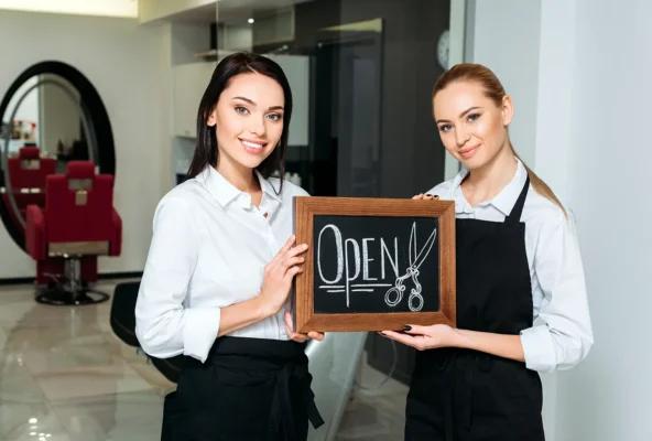Salon and spa owners with an open sign