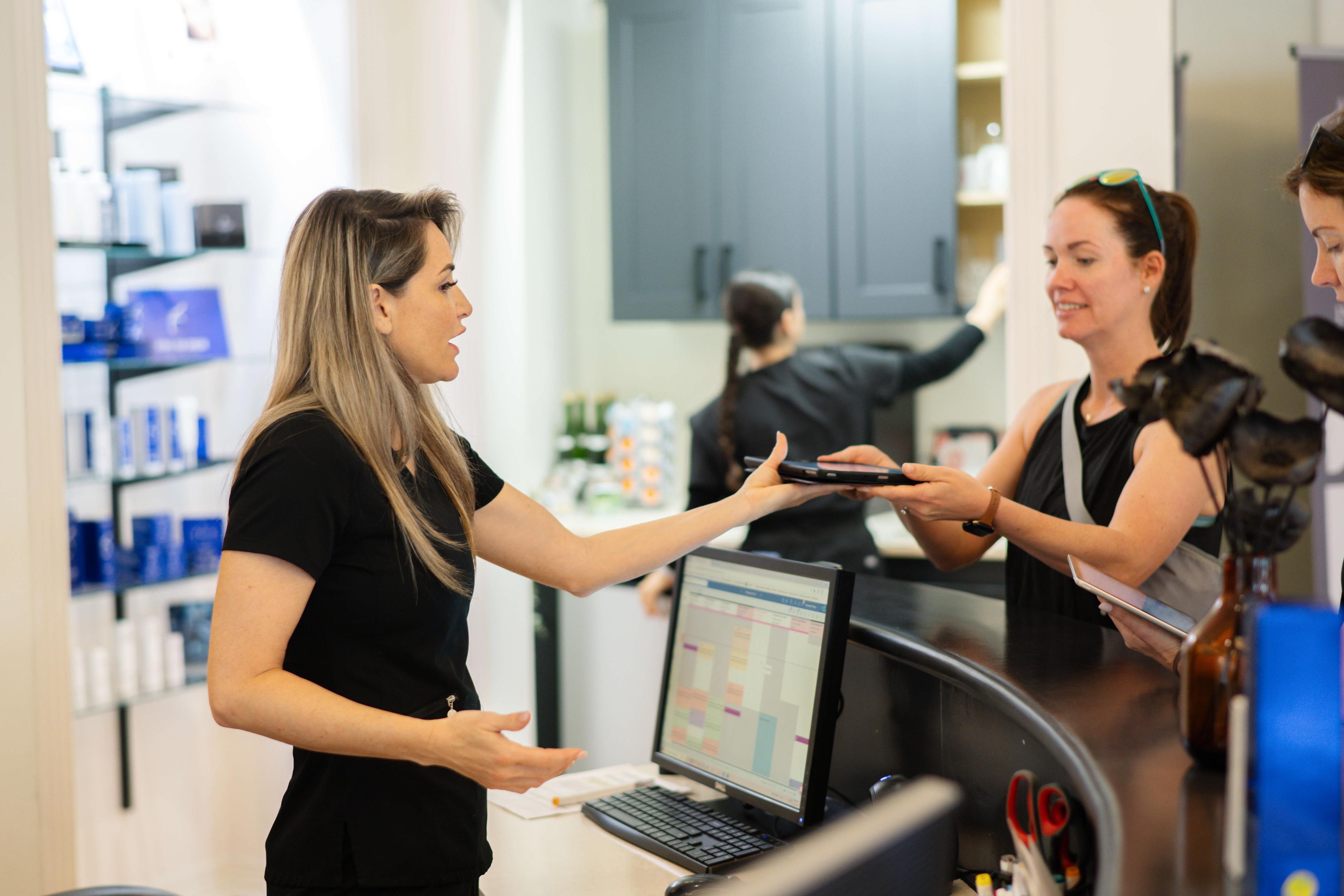 Spa staff member at front desk with guests